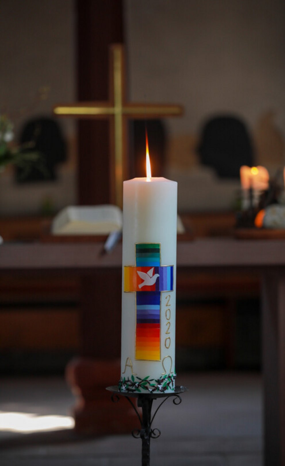 Brennende Osterkerze in einer Kirche.
