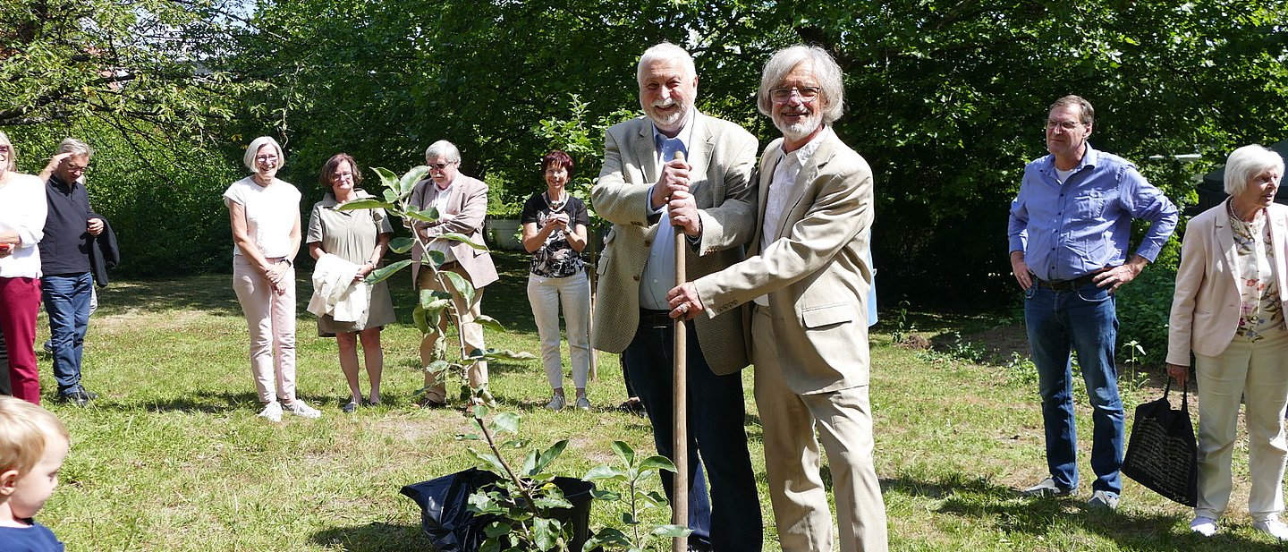 Anlässlich des ökumenischen Gemeindefests 2025 pflanzen Dr. Wolfgang Rollig für die Kath. Gemeinde St. Klara und Pfarrer Alexander Liermann für die Ev. Kirchengemeinde Klarenthal auf dem Gelände des künftigen Ökumenischen Zentrums ein Apfelbäumchen.