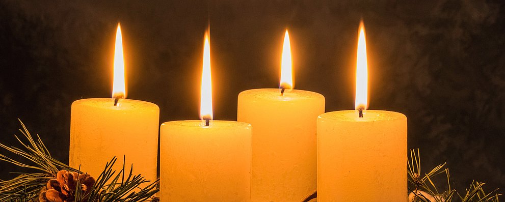 Adventskranz mit vier brennenden Kerzen