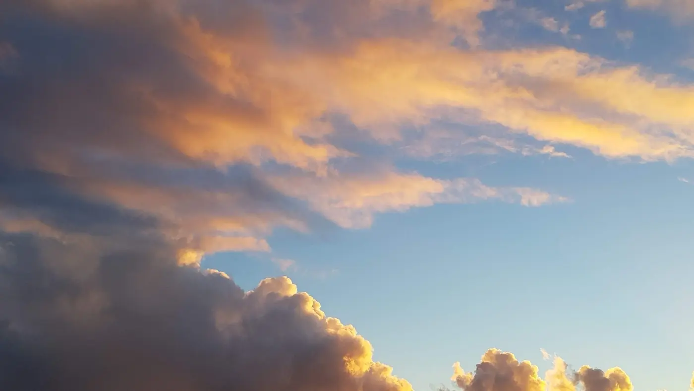 Wolken am Himmel angestrahlt von untergehender Sonne.
