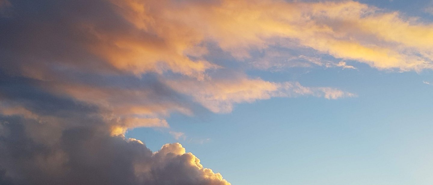 Wolken am Himmel angestrahlt von untergehender Sonne.
