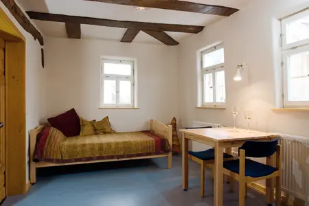 Zimmer mit Bett und Tisch