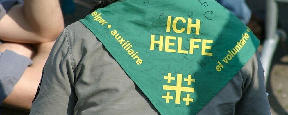 Eine Volontärin mit einer grün-gelben "Ich Helfe"-Schärpe am Kirchentag 2005 in Hannover.