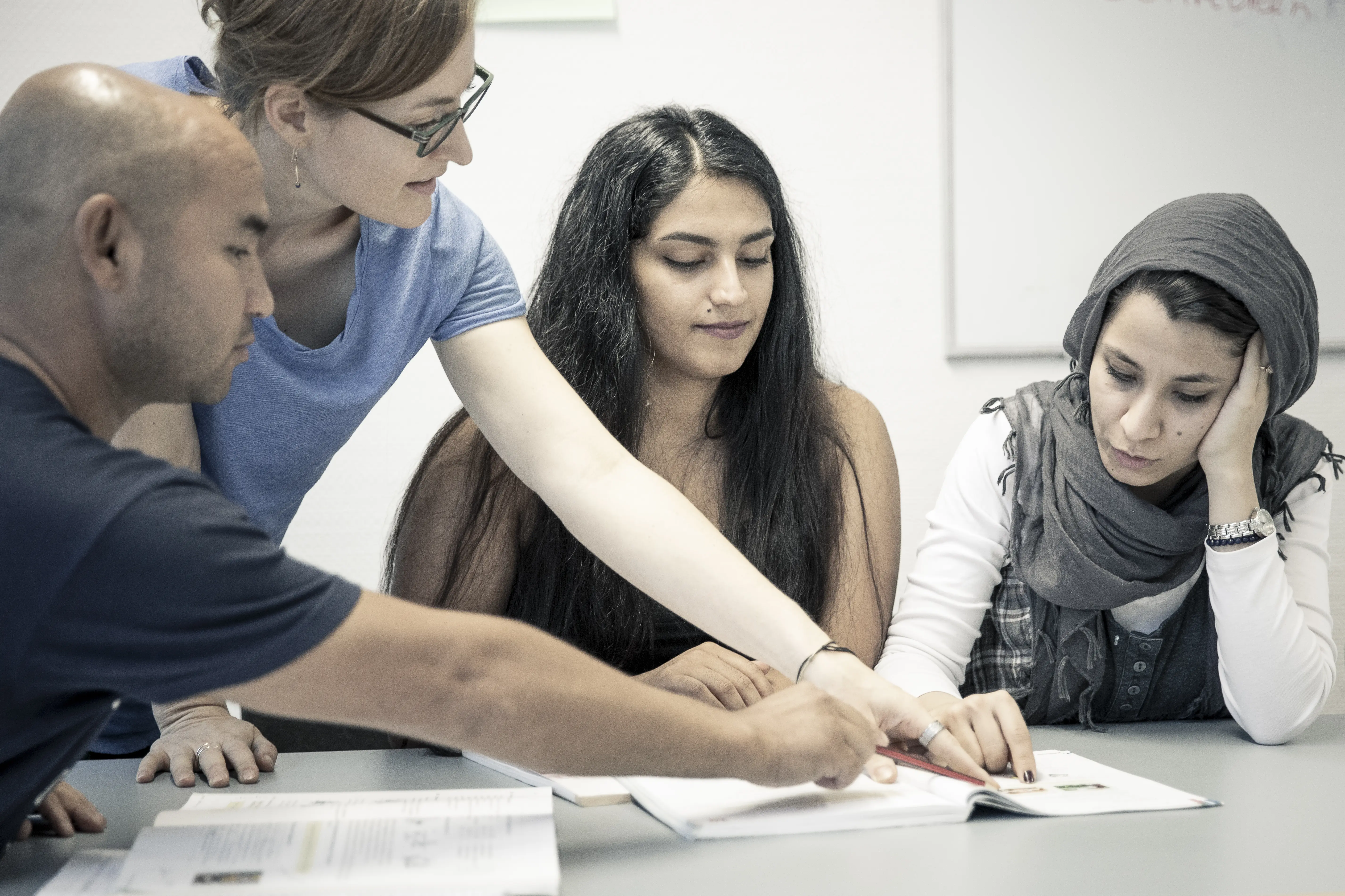 Geflüchtete mit einer Lehrkraft in der Sprachschule "Deine Chance"