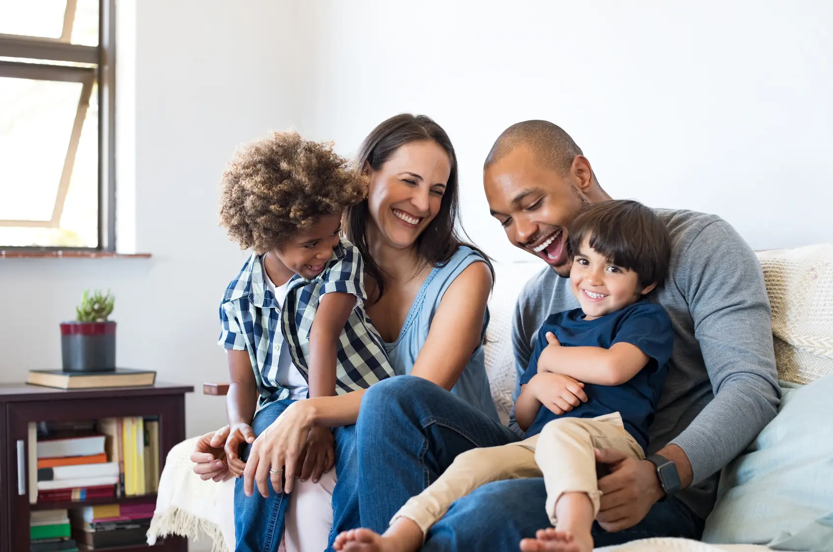 Eine Familie sitzt gemeinsam auf dem Sofa