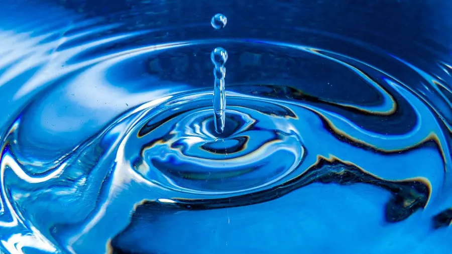 Ein Tropfen Wasser fällt auf eine Wasseroberfläche und bildet Ringe