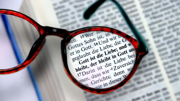 Brille liegt auf einer aufgeschlagenen Bibel
