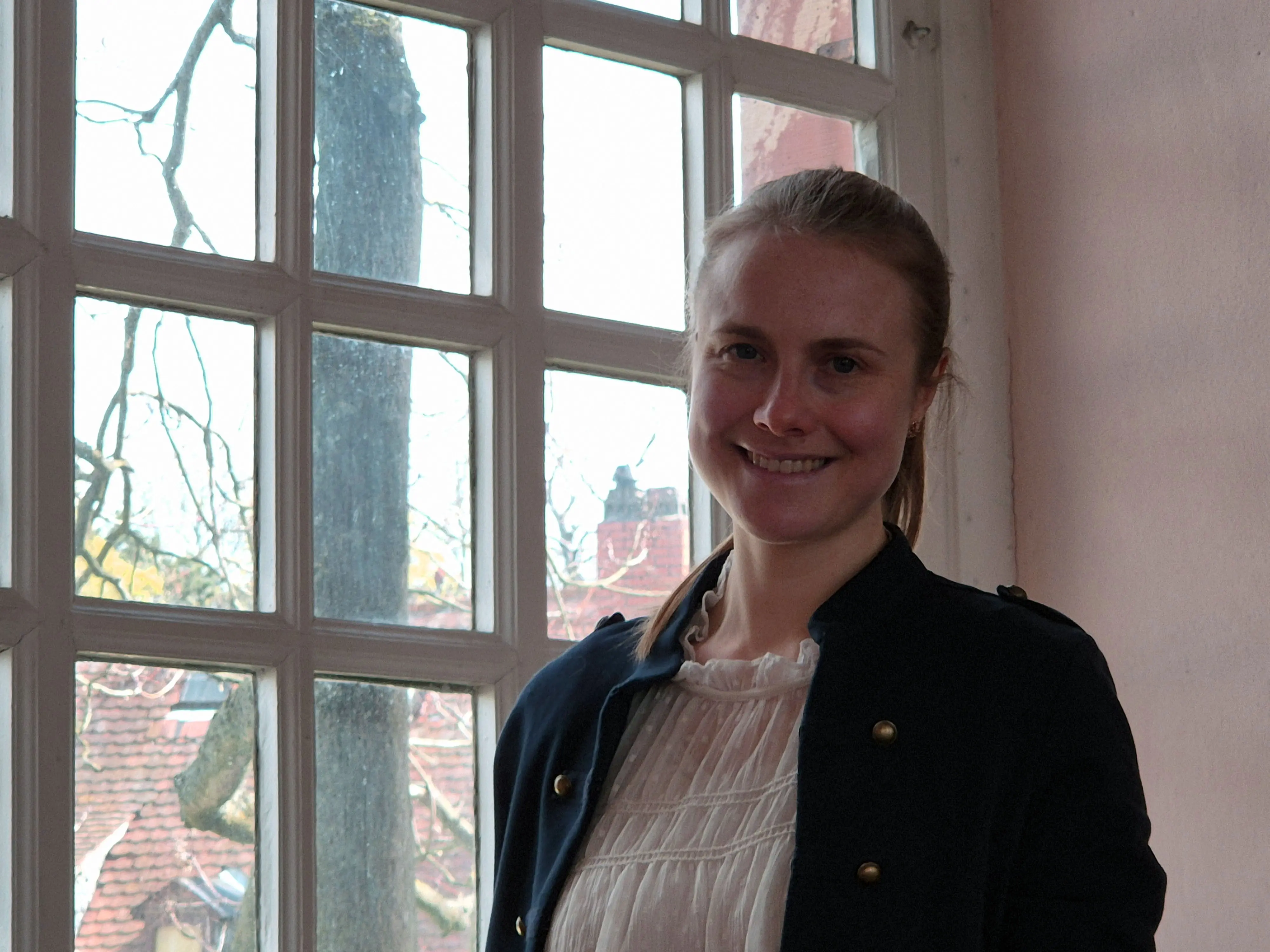 Portrait von Miriam Wolf vor einem Fenster der Ev. Kirche Liederbach