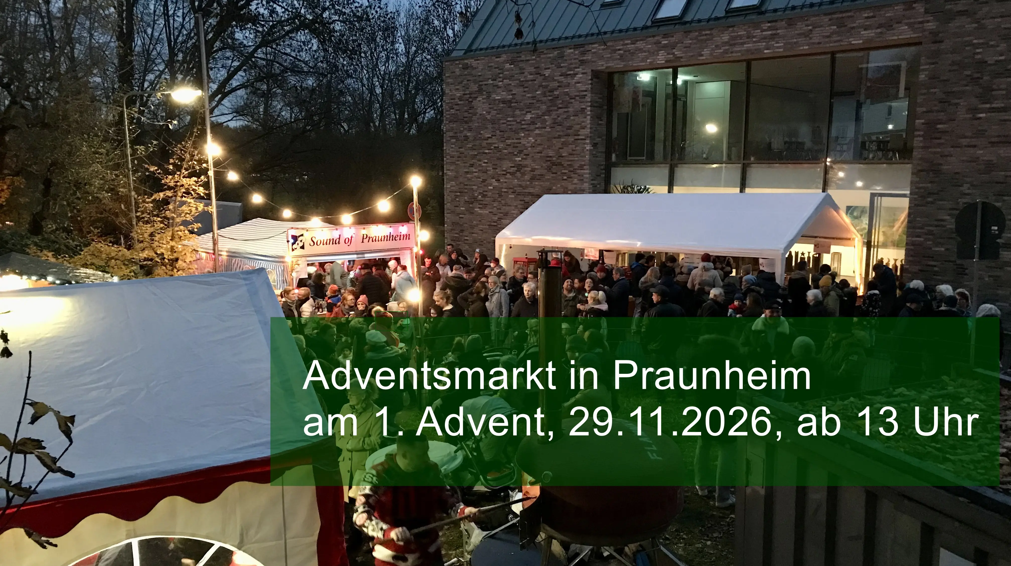 Adventsmarkt in Praunheim Blick vom Kirchgarten auf den Vorplatz des Gemeindeshauses in Praunheim. Der Platz ist weihnachtlich beleuchtet, es gibt Buden und viele Menschen besuchen den Adventsmarkt.