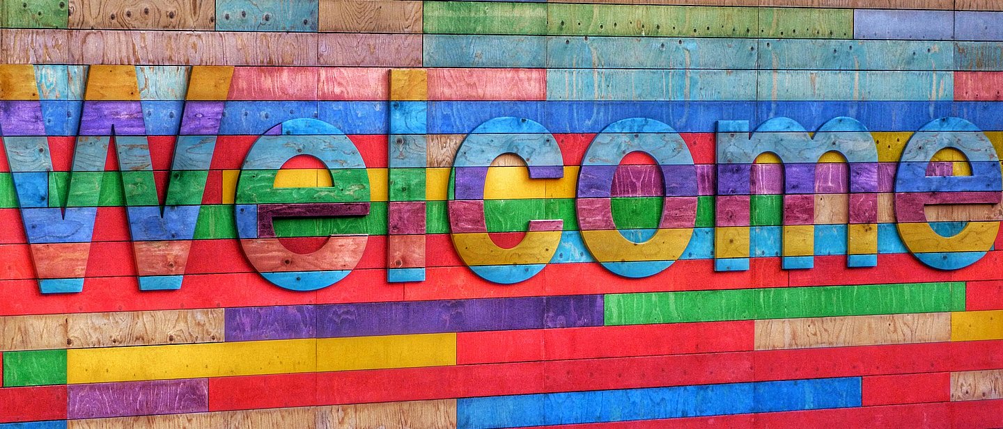 Bunte Wand mit Welcome-Schriftzug