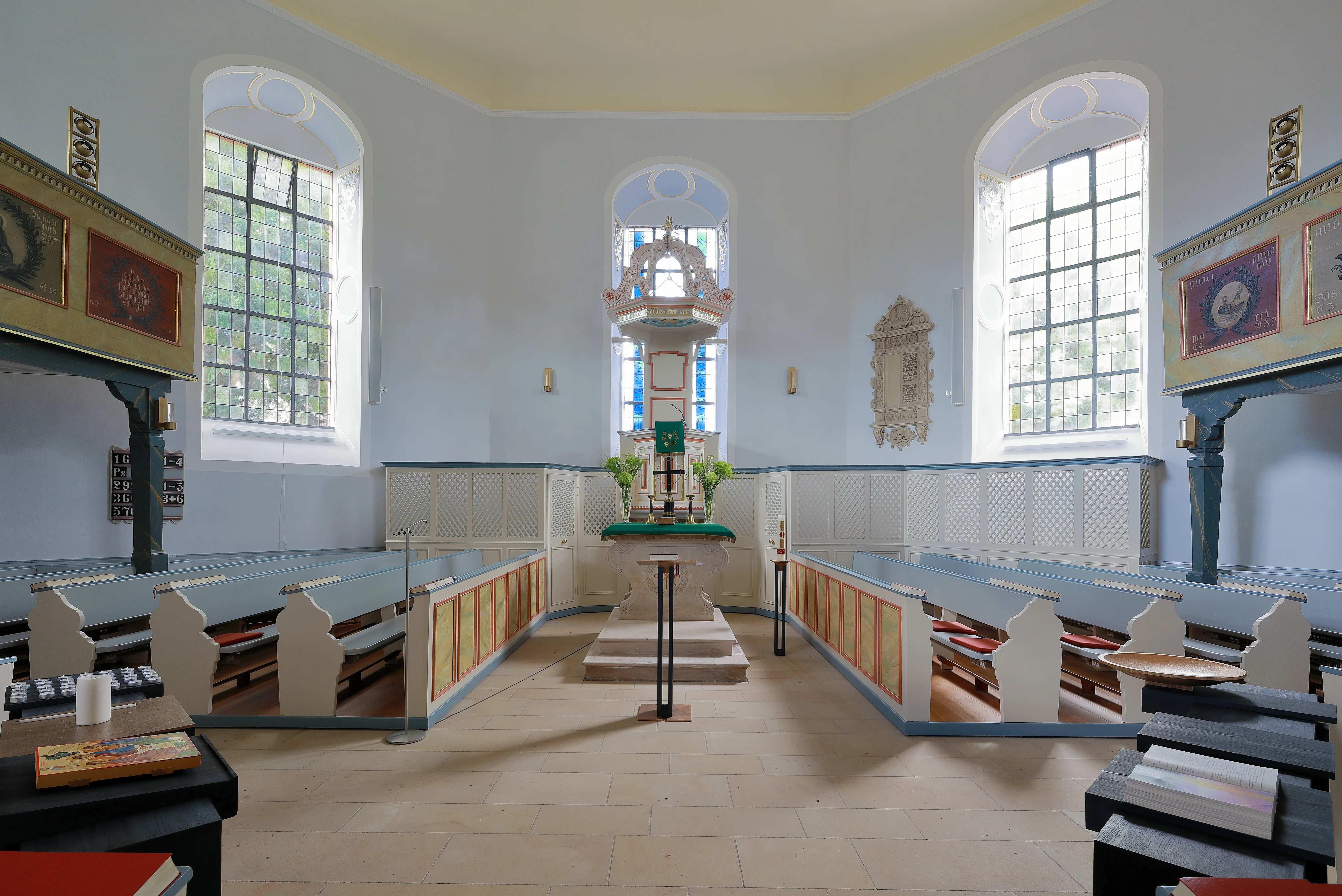 Evangelsiche Kirche Uelversheim: Innenansicht nach Osten mit Altar, Kanzel, Gestühel und modernen Kirchenfenster
