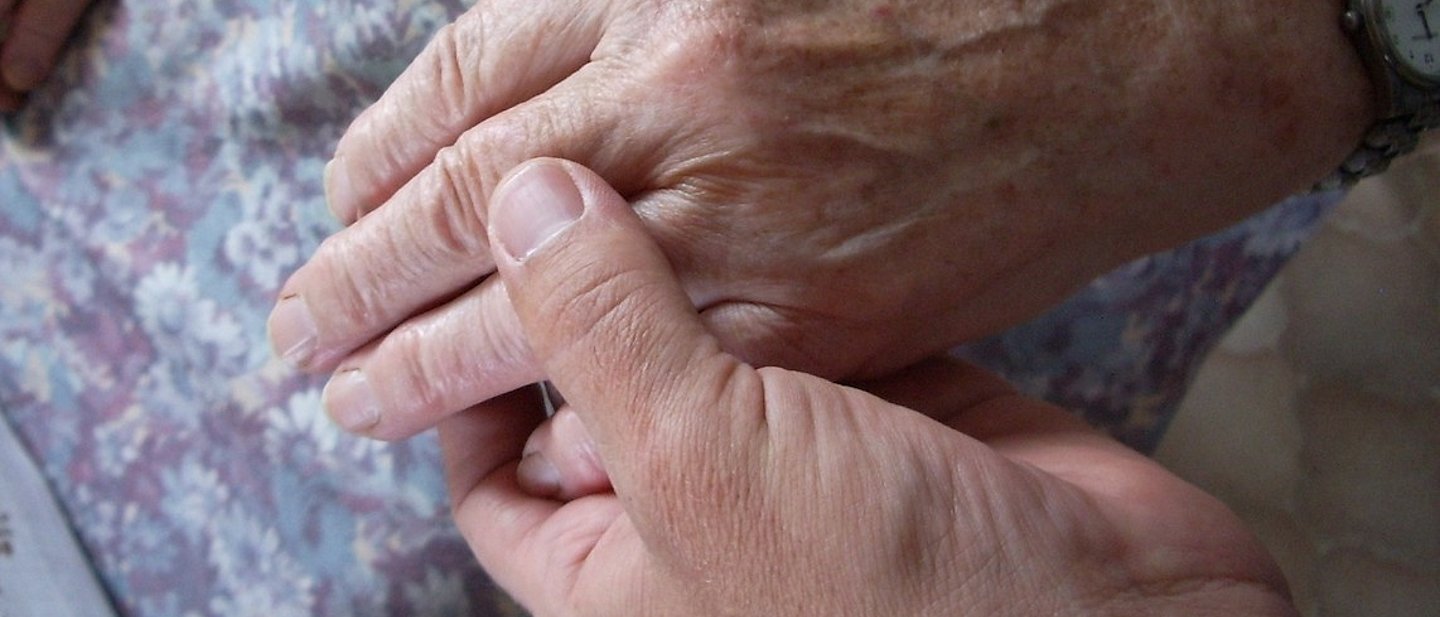 Junge Hand hält die Hand einer älteren Frau