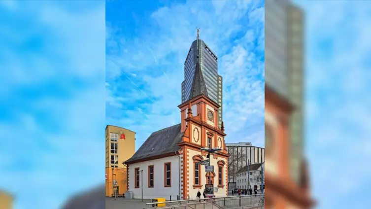 Ansicht der Kirche mit Hochhaus im Hintergrund
