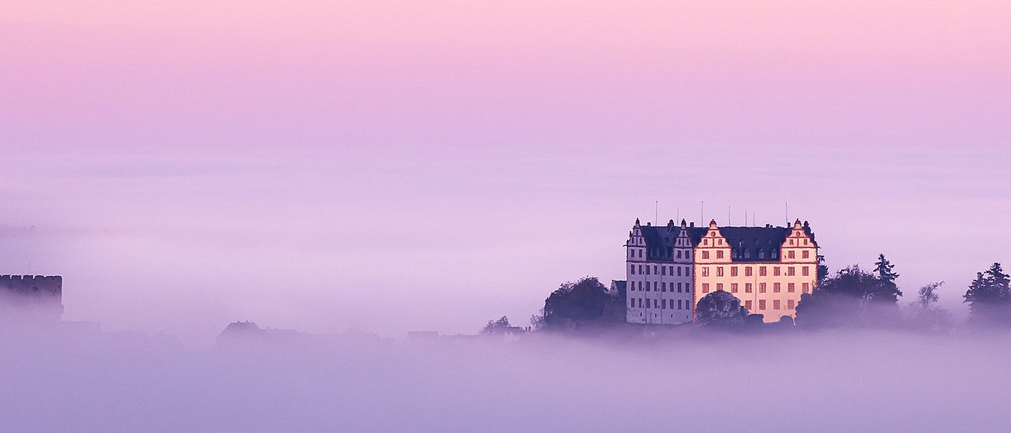 Schloss Lichtenberg im Nebel mit Morgenrot