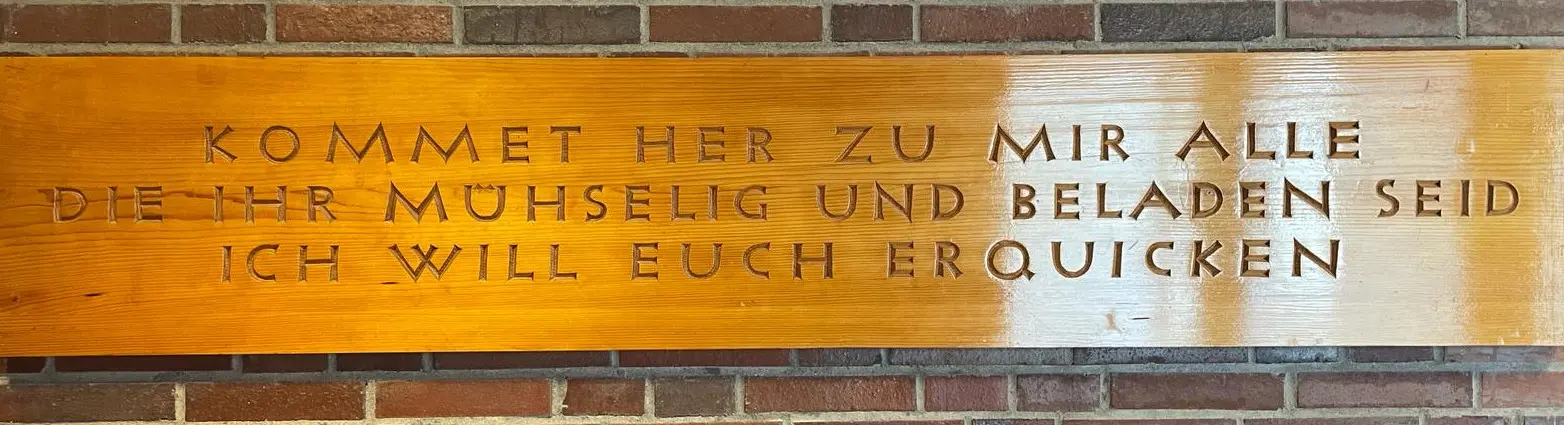 Holztafel mit Text: Kommt her zu mir alle, die ihr mühselig und beladen seid, ich will euch erquicken. (Matthäus 11,28)