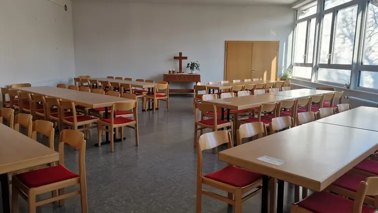 Saal mit Tischgruppen und Stühlen