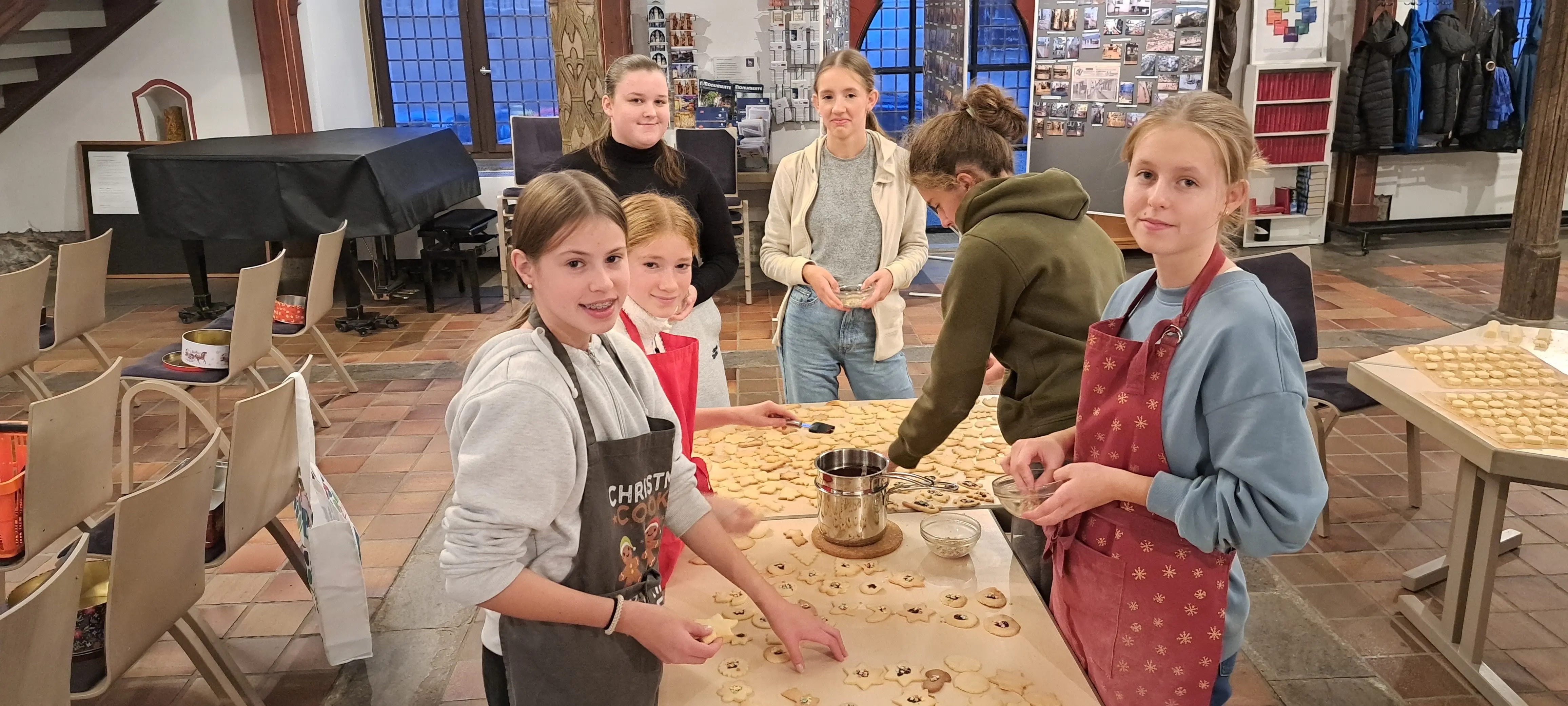 Das Foto zeigt die Konfis während der Vorbereitungen, Plätzchen backen, für die Adventsfeier der älteren Gemeindemitglieder im Jahr 2024.