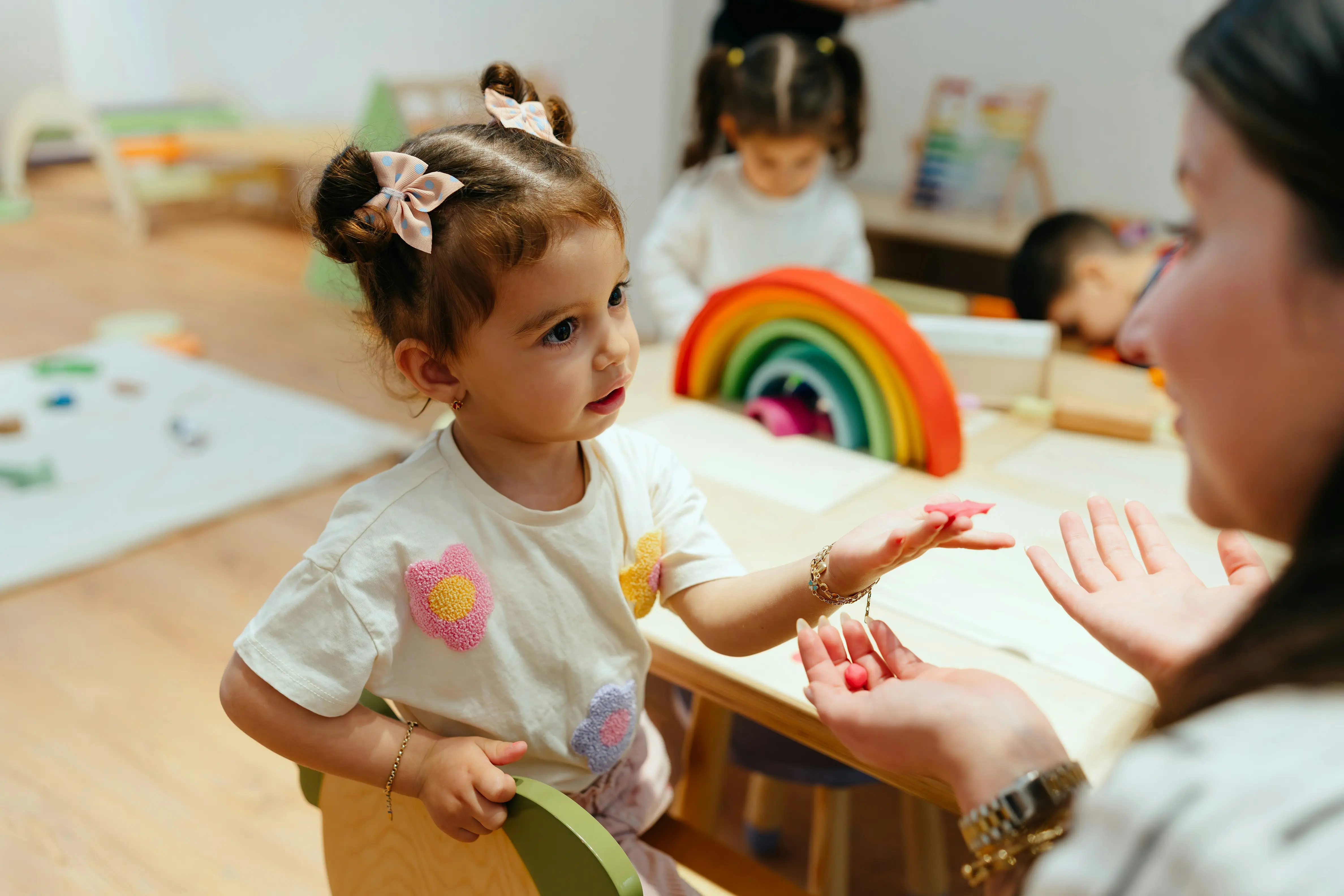 Kind mit Regenbogen und Frau, die etwas erklärt