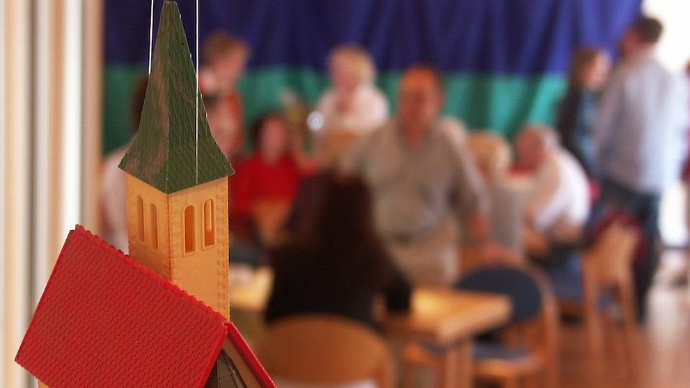 Modell einer Kirche mit Menschen im Hintergrund