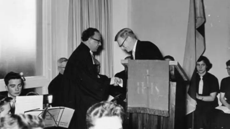 2 Personen gratulieren sich auf einer Kirchenkanzel anlässlich der Einweihung ev. Gemeindehaus Herrnsheim