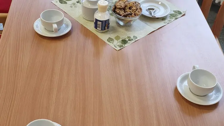 Tisch mit Tassen, Untertassen und Blumen.