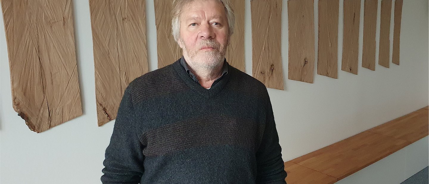 Herr Löffl steht vor den Wandtafeln