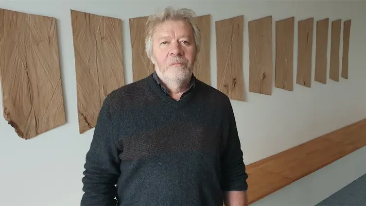 Herr Löffl steht vor den Wandtafeln