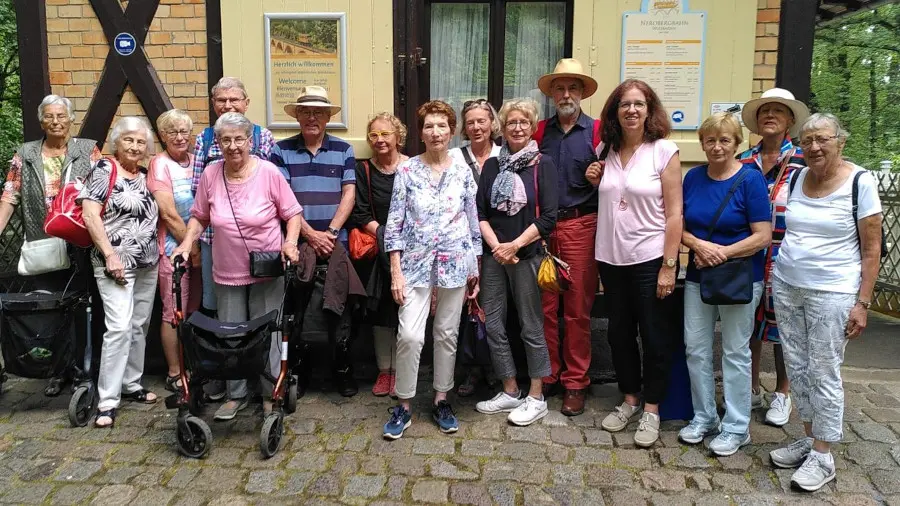 Eine Gruppe von Senioren steht an der Bergstation der Nerobergbahn Wiesbaden.