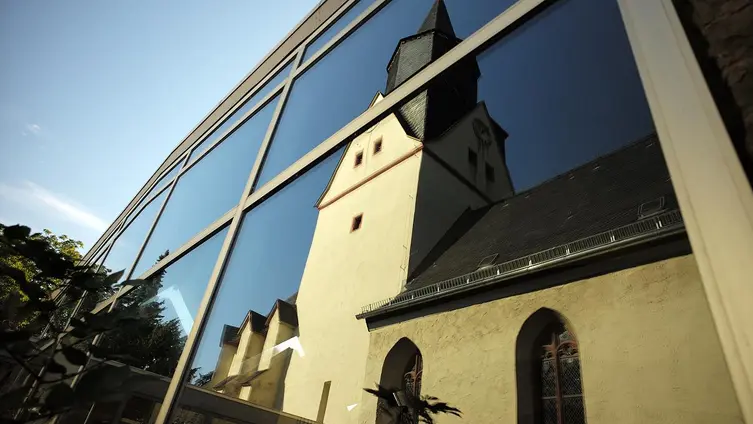 Die Alte Martinskirche spiegelt sich im Fenster der Neuen Martinskirche
