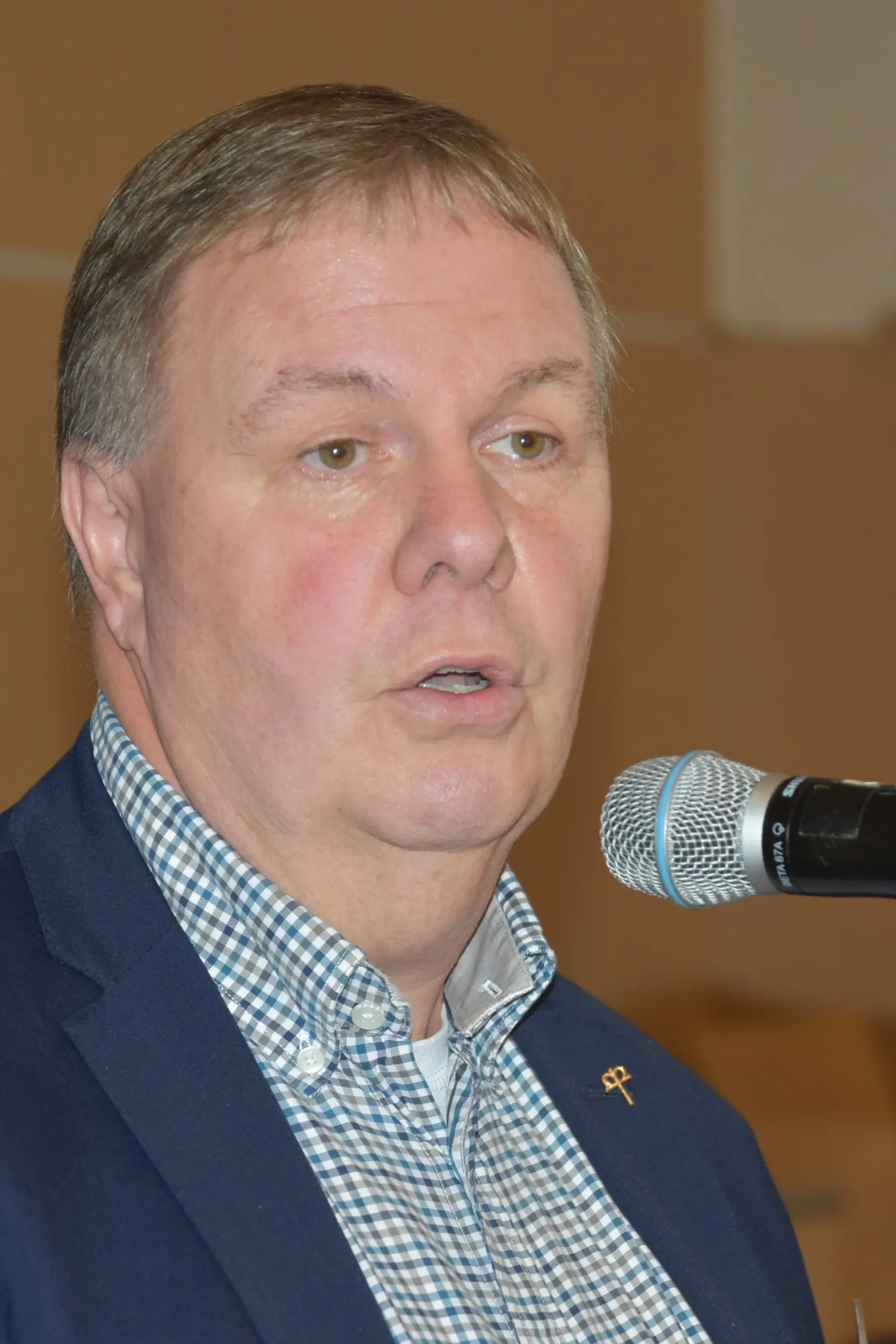 Christoff Jung, kurze Haare, blaues Jackett, spricht in ein Mikrofon