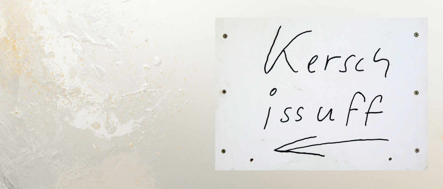 An einer hellverputzten Wand hängt ein Schild "Kersch is uff" mit Pfeil nach links