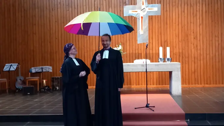 Dekanin Janott und Pfarrer Rupprecht mit Regenbogenschirm