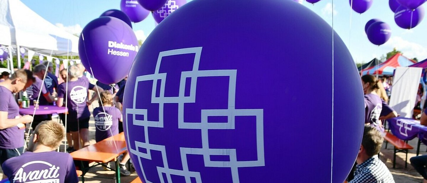Lila Ballons bedruckt mit dem weißen Facettenkreuz