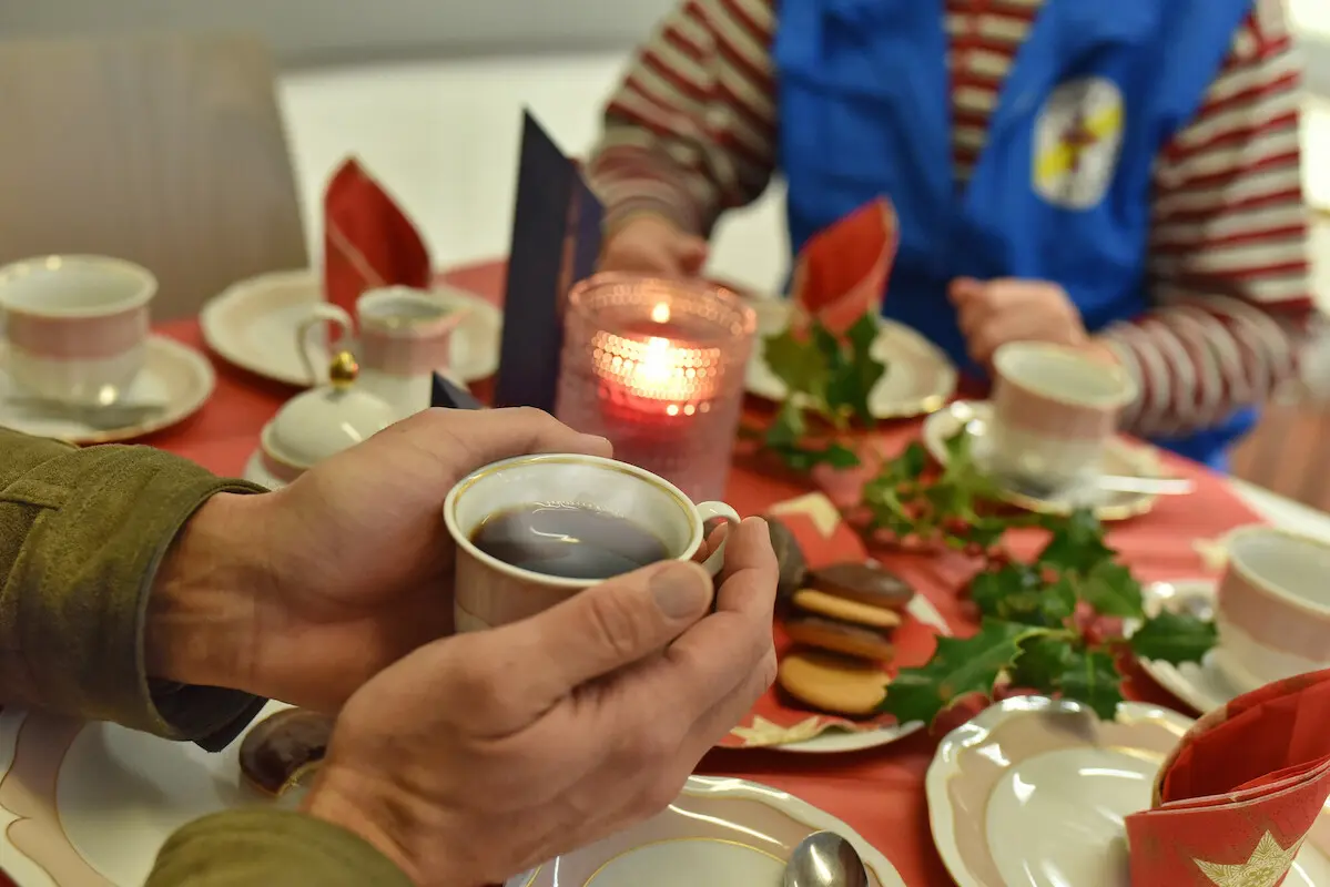 zwei personen sitzen an einem gedeckten Kaffeetisch