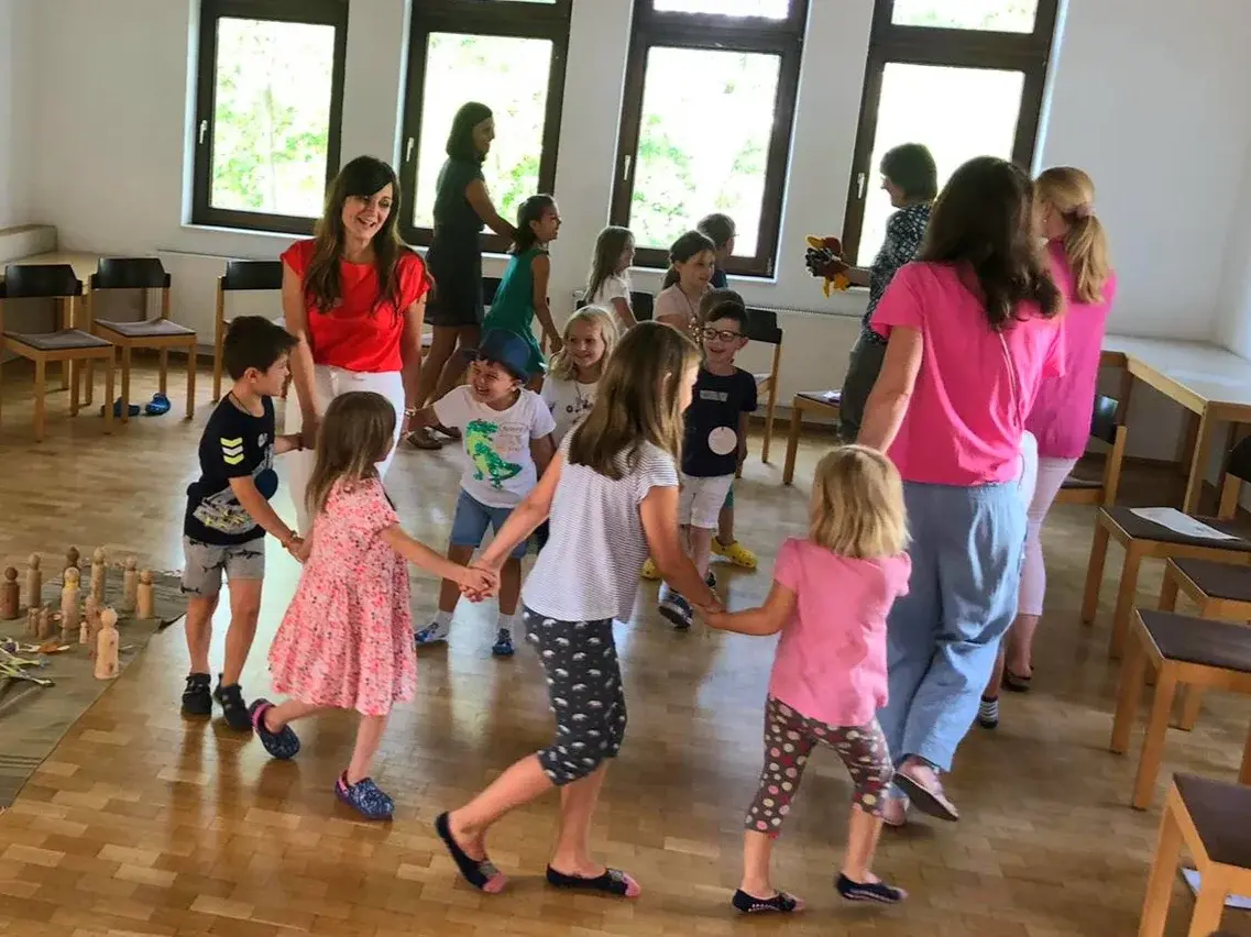Mütter und Kinder tanzen bei der KinderKirche im Gemeindehaus Burgholzhausen.
