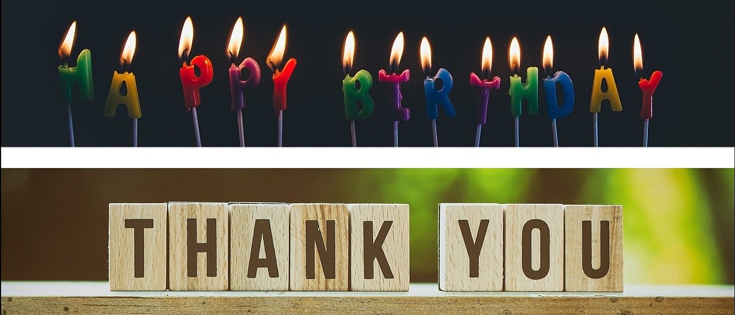 Oben brennen Kerzen aus Buchstaben, die Happy Birthday schreiben. Unten sieht man kleine Holzblöcke mit den Buchstaben Thank You.