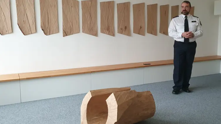 Herr Mai in Uniform steht vor dem Kunstwerk