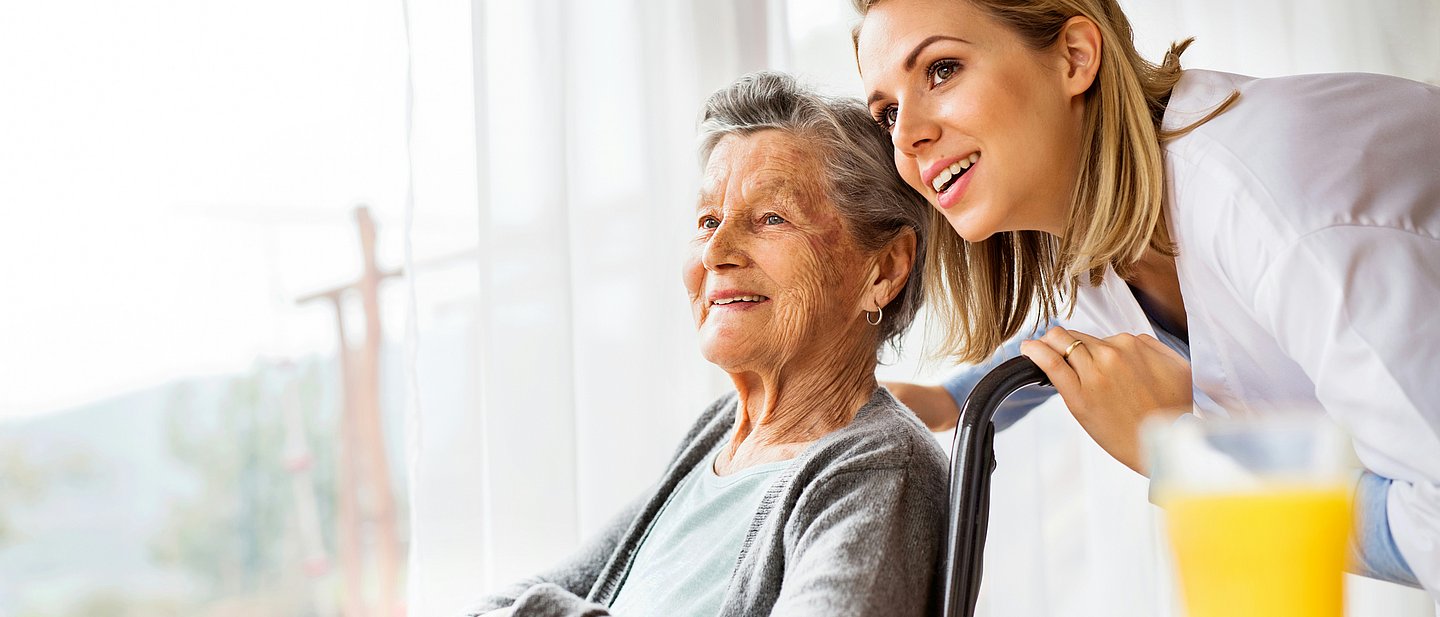 Jüngere Frau kümmert sich um eine ältere. 