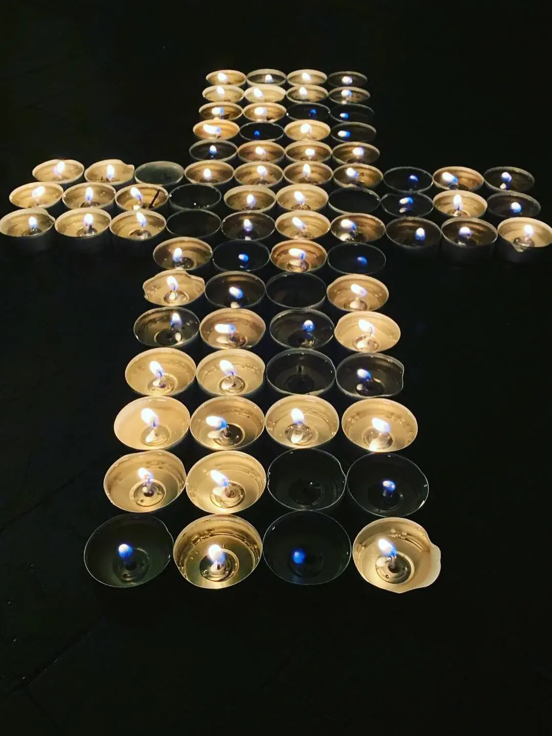 Teelichter zu einem großen Kreuz angeordnet.