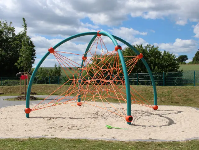 Ein modernes Klettergerüst steht auf einer Wiese.