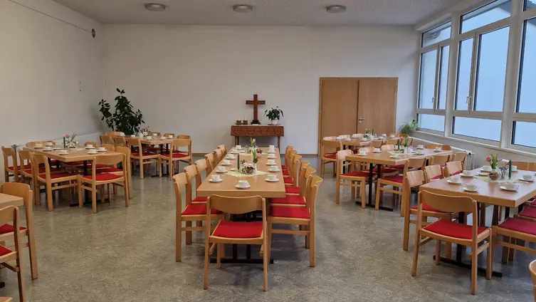 Saal mit Tischgruppen und Stühlen