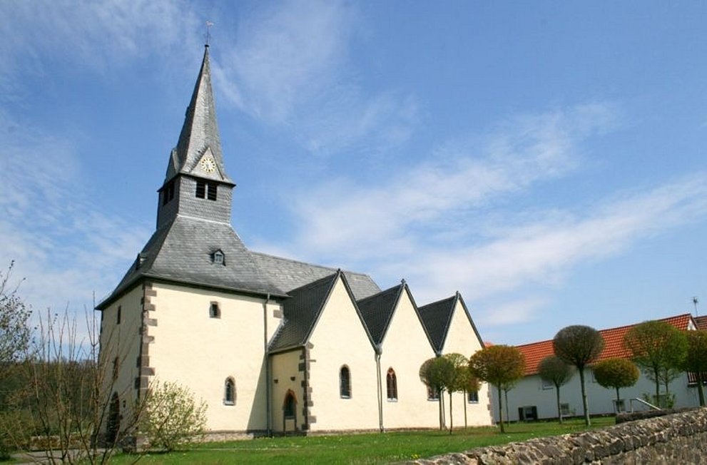 750 Jahre alte Kirche im Sonnenschein mit Garten davor