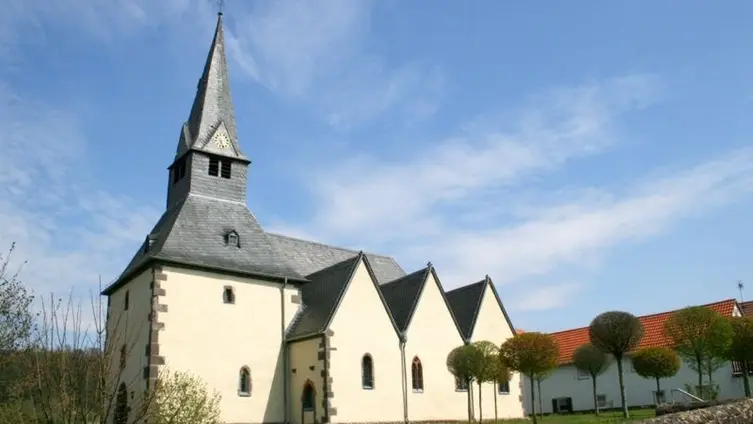 750 Jahre alte Kirche im Sonnenschein mit Garten davor