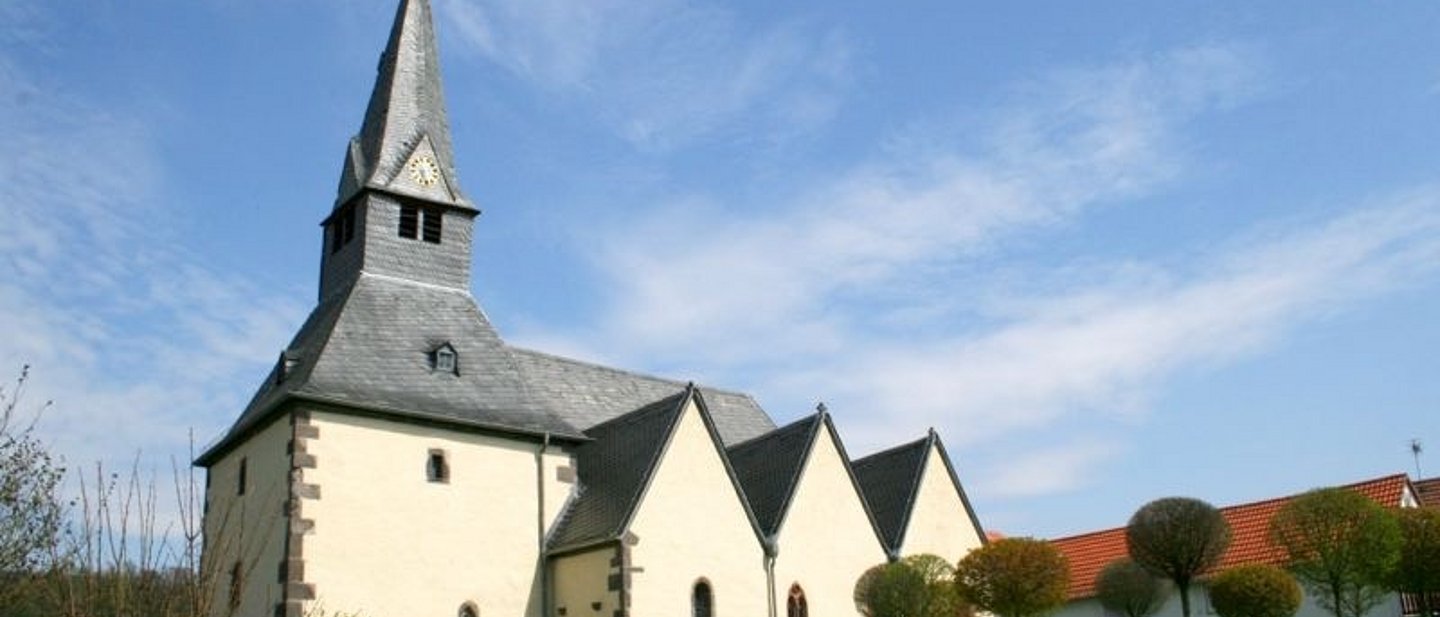 750 Jahre alte Kirche im Sonnenschein mit Garten davor