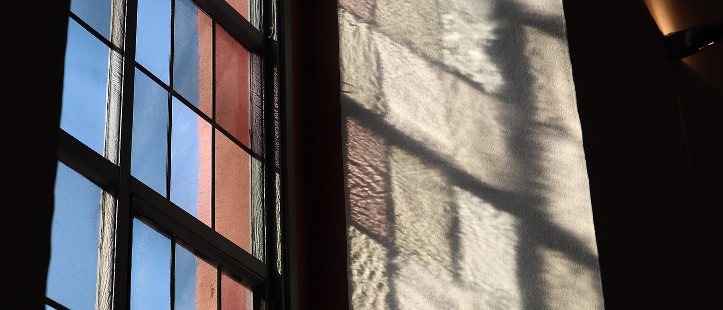 Blick vom Inneren der Kirche durch ein Fenster im Hintergrund ist blauer Himmel