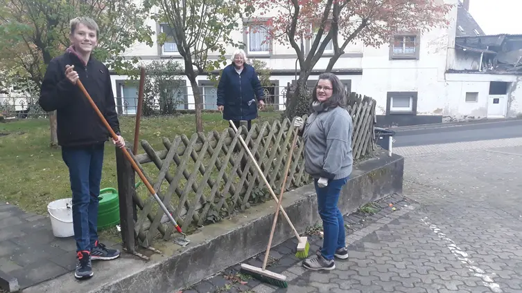 Das Foto zeigt 3 Aktive der Garten- und Handwerksgruppe bei ihrer Arbeit am Außengelände der Markuskirche.
