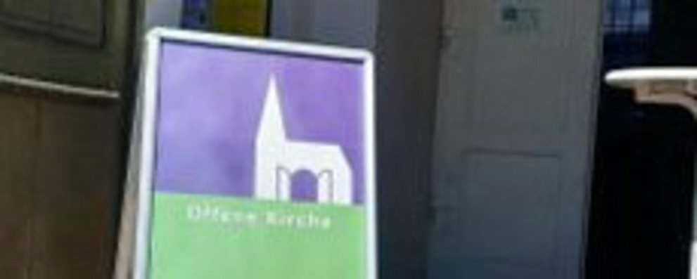 Eingang zur Hugenottenkirche Friedrichsdorf mit dem Schild "Offene Kirche"